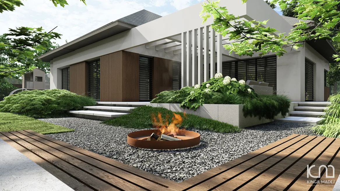 Narożna ławka przy palenisku postawiona pod klonem palmowym. Widok na dom. Skarpy porośnięte kosodrzewiną mugo.