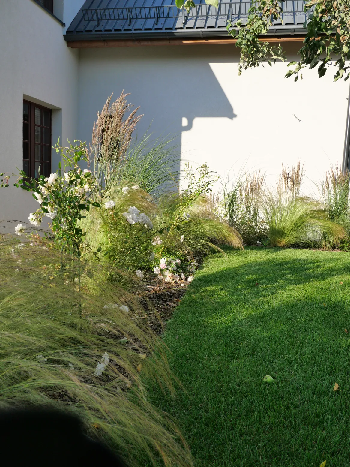 Rabata pełna traw ściłkowana korą. Wykończenie trawnika: rant angielski.