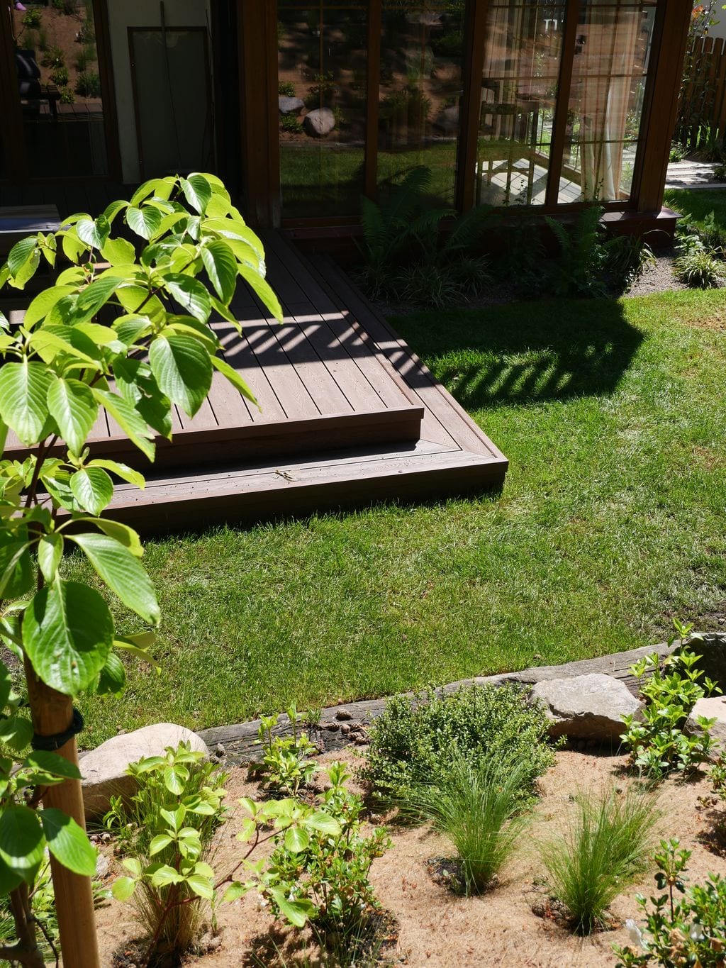 Widok na główny taras ze skarpy wyłożonej matą kokosową z nasadzeniami bylinowo-trawiastymi.